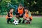 Professional soccer coach tells the strategy of football game to his attentive teen players at stadium during training.