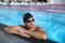 Professional sport swimmer athlete portrait at swimming pool. Active lifestyle healthy fit man wearing cap and goggles