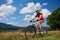 Professional sportsman rider in sportswear and helmet cycling bicycle in high grass