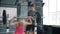 Professional sportsman teaching young woman in gym during bodybuilding workout with barbell