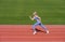 Professional sportswoman during running training session. Woman on stadium track. Sportswoman wearing sportswear