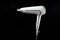 Professional stylish hairdryer isolated over a black background. White Ionic Hair Dryer with Hair Care Tool