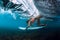 Professional surfer woman with surfboard dive underwater with barrel ocean wave.