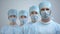 Professional surgeon team in mask and uniform looking at camera, hospital work