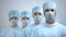 Professional surgeon team in mask and uniform looking at camera, hospital work