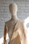 Professional tailoring mannequin. Female mannequin with wooden hands on wall background for displaying clothes