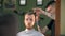 Professional tattooed barber giving a new haircut to his client in a barbershop