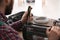 Professional technician repairing electric halogen heater with screwdriver at table indoors, closeup