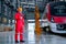 Professional technician worker stand near the train and hold and look to mobile phone in electrical or metro train factory