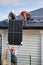 Professional technicians lifting solar panels on a roof of house