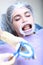 Professional teeth cleaning. Caries prevention. A young girl at the dentist`s appointment. Retractor in the mouth. Hands