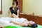 Professional therapist giving relaxing reflexology Thai oil leg massage treatment to a woman in spa