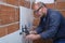 Professional tiler adjusting the separation between tiles on the wall.