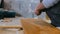 Professional tiling carpenter measures and marking a wooden plank at construction site