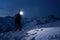 Professional tourist commit climb on great snowy mountain at night. Wearing backpack, headlamp and ski wear. Backcountry.