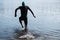 Professional triathlete swimming in river& x27;s open water. Man wearing swim equipment practicing triathlon on the beach in