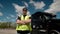 Professional Truck Driver in a yellow waistcoat approaches his truck and crosses his arms Behind Him Parked Long Haul