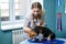 Professional vet funny female doctor examines a small adult dog. Caucasian cute pretty female vet works in a veterinary clinic