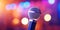 Professional vocal microphone on stage with a bokeh backdrop of concert lights. Karaoke concept. Generative AI