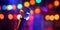 Professional vocal microphone on stage with a bokeh backdrop of concert lights. Karaoke concept. Generative AI