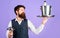 Professional waiter in uniform with serving tray and wine cooler. Restaurant serving. Butler carrying restaurant cloche