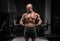 Professional weightlifter posing in the gym with a barbell in his hands. Classic bodybuilding