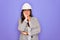 Professional woman engineer wearing industrial safety helmet over pruple background thinking looking tired and bored with