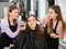 Professional women makeup artists applying shadows and blush to young client