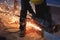 Professional worker cuts metal by angle grinder machine. Fountain of sparks. Fire safety at construction site