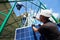 Professional worker installing solar panels on the green metal construction