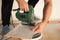 Professional worker using jigsaw during installation of new laminate flooring, closeup