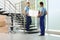 Professional workers carrying cabinet at stairs in office