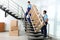 Professional workers carrying wooden rack on stairs in office