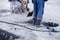 Professional workers in uniforms repair the road, cut off the asphalt layer and fill the pits with bitumen shovel. Concept