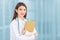 Professional Young Asian woman doctor wearing white robe and stethoscope sitting holding clipboard reporting patient report in the