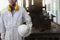 Professional young Asian worker with safety uniform standing in factory with vertical band saws machine background.