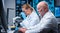 Professor and doctor work in a modern scientific laboratory using equipment and computertechnologies. Group of