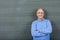 Professor With Hands Folded Standing Against Chalkboard