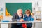 Professor and pupil in classroom at the elementary school. Child at school lesson with senior teacher.