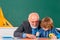 Professor and pupil in classroom at the elementary school. Elementary school. Pupil in class draw with teacher.