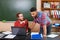 Professor Show Laptop Computer To Young Hispanic Student, University Teacher Discussion