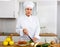 Proffesional woman cook in white uniform chopping vegetables