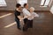 Proficient dancer teaching retired couple tango in the ballroom