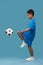 Profile of boy kneeing soccer ball