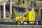 Profile of bright yellow classic bonnet big rig semi truck long haul tractor with black covered semi trailer driving on the