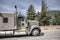 Profile of classic big rig semi truck with truck driver rest compartment transporting cargo climbing uphill on the mountain
