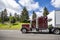 Profile of classic burgundy big rig semi truck with slipper compartment transporting cargo in dry van semi trailer running on the