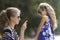 Profile close-up portrait of frustrated young blond woman talking to young small child girl.