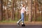 Profile of experienced skilled active young woman rollerskating with pleasure, being on road near forest, sticking to healthy