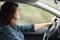 Profile of a happy woman driving a car